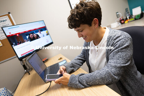 Sara Troupe composes a message on her phone to a student. Academic navigators like Sara, who works w