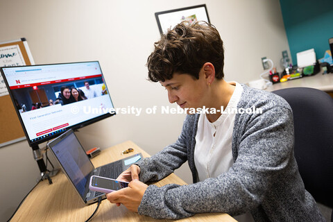 Sara Troupe composes a message on her phone to a student. Academic navigators like Sara, who works w