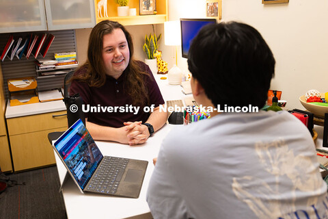 Jordan Heim chats with Jimmy Truong, a junior studying supply chain management, in his office in the