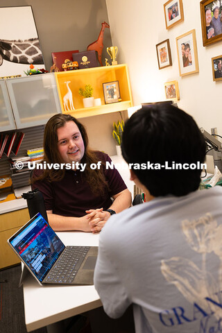 Jordan Heim chats with Jimmy Truong, a junior studying supply chain management, in his office in the