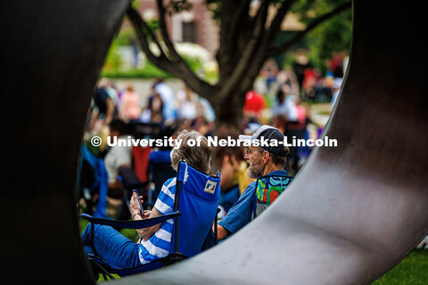 A couple sits in front of the Fragment XO sculpture while enjoying the final session of Jazz in June