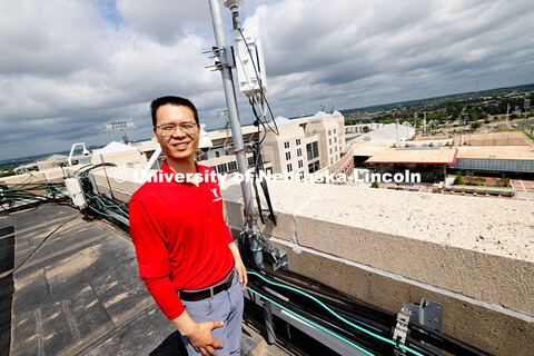 Qiang Liu, assistant professor in the School of Computing, stands next to one of the Husker-Net 5G a