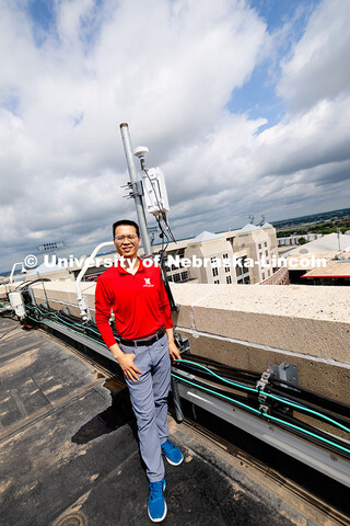 Qiang Liu, assistant professor in the School of Computing, stands next to one of the Husker-Net 5G a