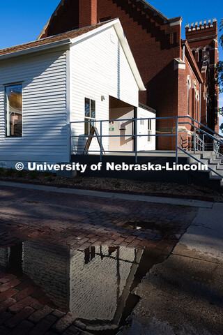 A puddle in the alleyway reflects the exterior of the Art Chapel, located on the north side of the F