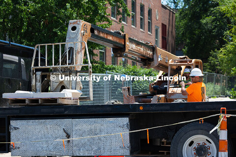 Ostin Gustafson guides Charles Tucker, truck lift operator to place a pallet of stone on a flatbed. 