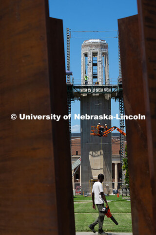 Kehm Construction employees use a power lift to get down from working on Mueller Tower. In front of 
