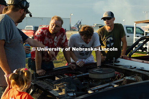 Ian Gouldie, a robotics engineering major, peers into the engine of the UNL Figure 8 Racing Team's 1
