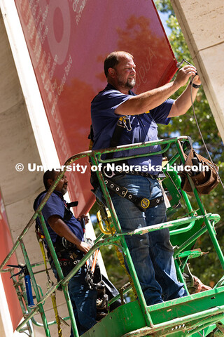 Justin DeBoer (right) and Geraldo Martinez (left), both exteriors technicians at UNL, adjust the cab