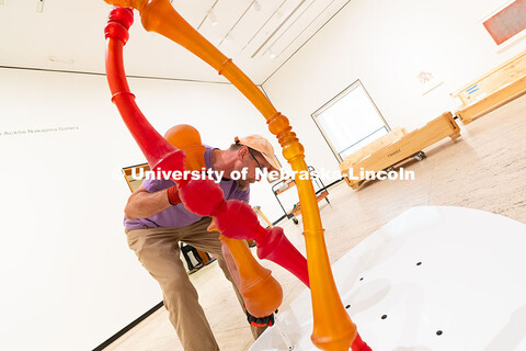 Delan Lonowski, an on-call exhibition technician for the Sheldon Museum of Art, fits one of the smal
