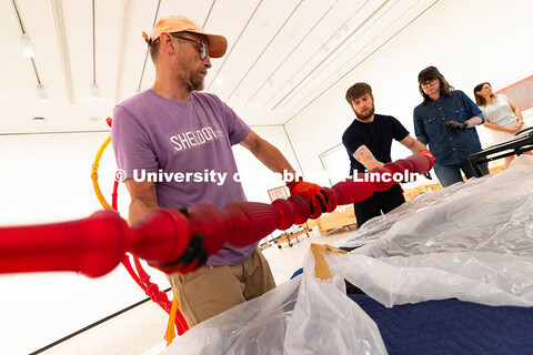 Delan Lonowski (left) and Quentin Fortney (right), on-call exhibition technicians, move part of a sc