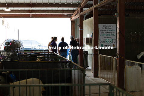 A group of 4-H competitors chat at the edge of the livestock barn at the Otoe County Fair in Syracus