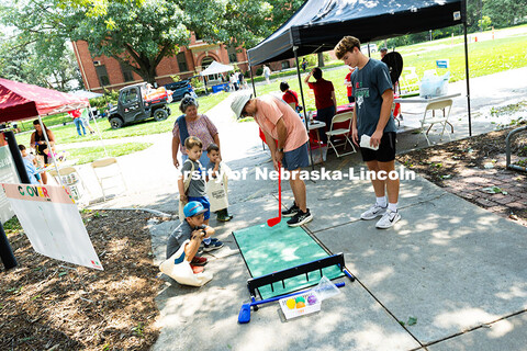 Jim Kolbo uses a plastic putter to aim for the target in a probability game at the 4-H booth during 