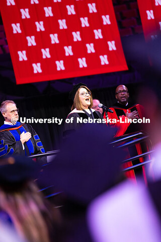 Dr. Jaime Reimer Seaman, professor of music, sings the National Anthem at the start of the summer co