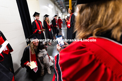 Emmerson Putnam snuggles Cash, the University Police Therapy Dog (goldendoodle) who provides support
