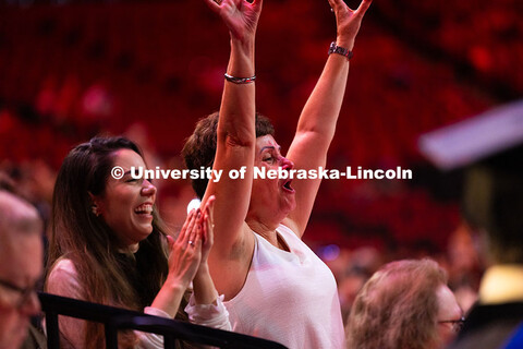 Vinicius Andrade's mother and wife cheer as he walks up to be hooded during the summer commencement 