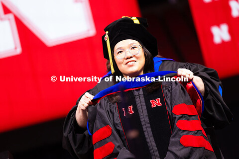 Justine Yeo smiles as she is hooded during the summer commencement ceremony. Summer Commencement cer