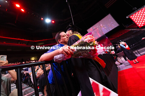 Amanda Smith pauses for a hug from her partner after receiving her diploma. Summer Commencement cere