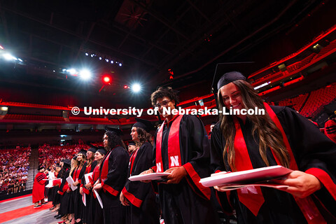 Graduates grin after receiving their diplomas. Summer Commencement ceremony in Pinnacle Bank Arena. 