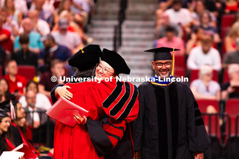 Weiman Xu hugs a professor after receiving her doctorate during the summer commencement ceremony. Su