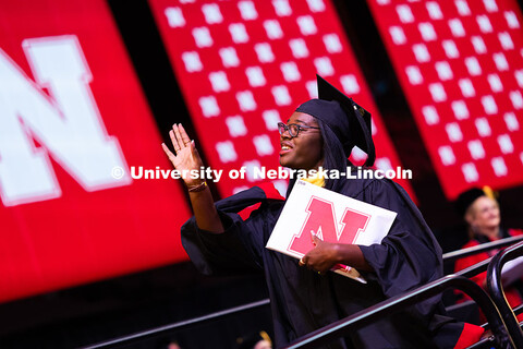 Ma'Kiya Carter waves to a friend after receiving her diploma at the summer commencement ceremony. Su