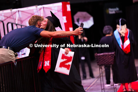 Payton Kleidosty gives her partner, Kyle Hansen, a kiss after receiving her diploma. Hansen waited a