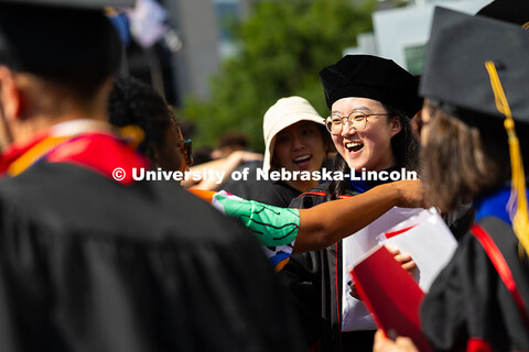 Weiman Xu gets a hug from former classmate and previous graduate, Genese Clark, after the summer com