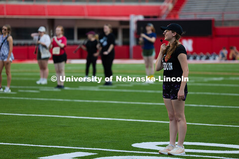 Gretchen Muth, a senior studying French and global studies, leads the UNL band in warm-up exercises 