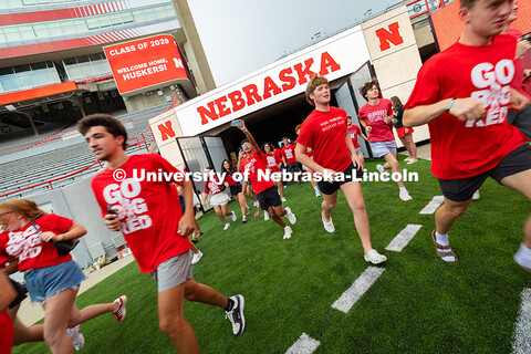 Students run onto the field during the Tunnel Walk into Memorial Stadium. The Tunnel Walk is for inc