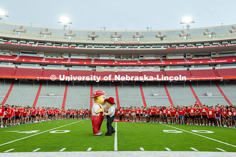 Herbie Husker and Lil' Red have a chat on the field as the Freshman students form an N on the Memori