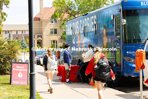 Students walk by a Nebraska Community Blood Bank bus during the first campus blood drive of the year