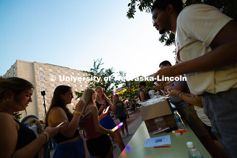 Students line up to get glow sticks from the resident assistants outside of Harper Residence Hall du