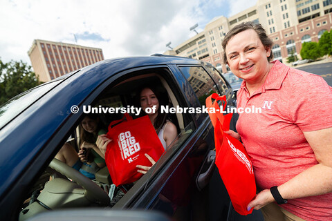 Dee Dee Anderson, Vice Chancellor for Student Life, hands swag bags to Jessica Longacre and her room