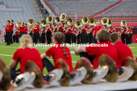 Cymbal players watch from the sideline as students showcase marching exercises during the band exhib