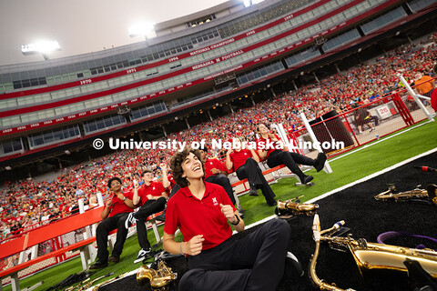 Members of the tenor sax line dance and sing during a drumline performance within the marching band 