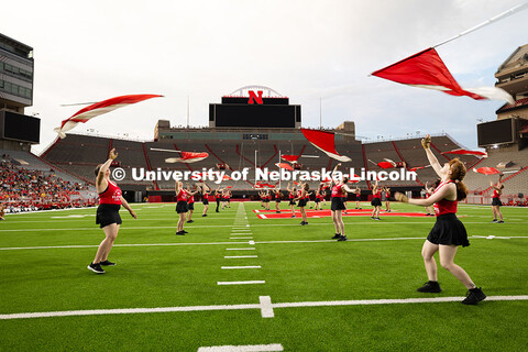 The color guard toss their flags during a performance in Memorial Stadium as part of the band exhibi