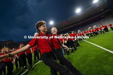 Piccolo players Ceilus Ibarra and Natalie Schmersal skip off the field together after the marching b