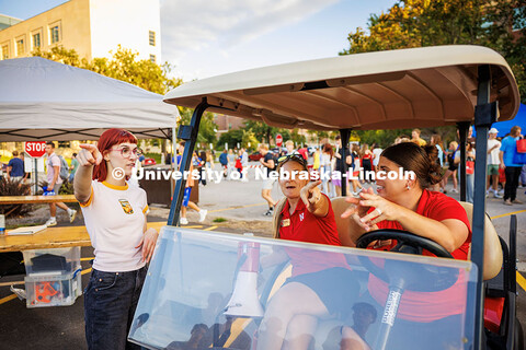 Kalan Walters drives the golft cart (right) as Hollie Swanson directs a student where to go during t