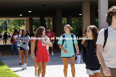 A pair of friends walk in front of Love Library North on their way to class for the first day of cla