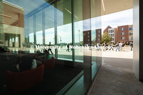 Students chat and study in Kiewit Hall as other students leave the building for their next class. Fi