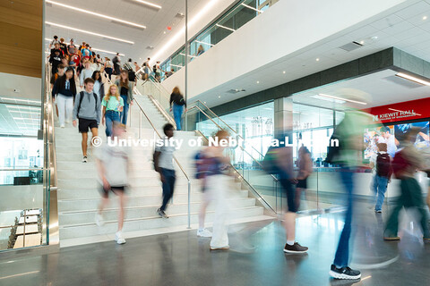 Students walk down the central staircase in Kiewit Hall on their way to classes or lunch on the firs