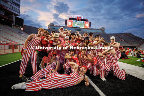The Husker Bib Crew wear red and white striped bib overalls and pose for a photo during the Nebraska