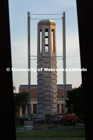 Morning sunlight touches Mueller Tower's exposed brick as scaffolding supports surround it as constr