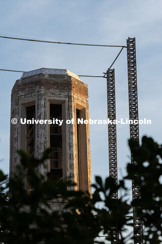 Morning sunlight touches Mueller Tower's exposed brick as scaffolding supports surround it as constr