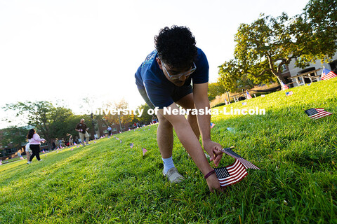 Leonardo Luna-Duran, a sophomore in the Clifton Builders management program, places flags in the gra