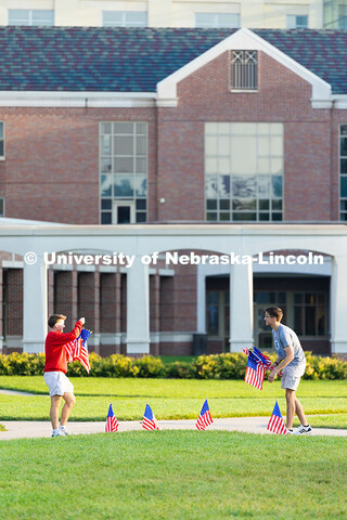 Two student volunteers place flags in the grass of the Meier Commons to commemorate September 11, 20