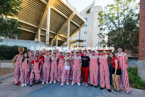 Husker students wear bibs and pose for a group photo outside of Memorial Stadium before the football