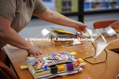 Regina Flowers, a library staff member works on choosing display stands for Karen Blessen’s journa