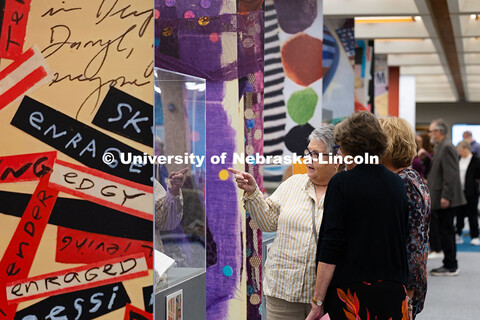 Visitors view “The Muck, the Seeds, the Weeds, the Blossoming: The Journals of Karen Blessen,” a