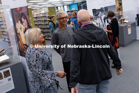 Sue and Don Brouse (left) chat with Keith Engelmann in front of displays featuring the journals of a