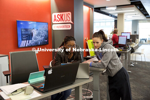 Jasmine Meeks (from left), a member of the Huskertech help desk team, assists Nicole Helm, a junior 